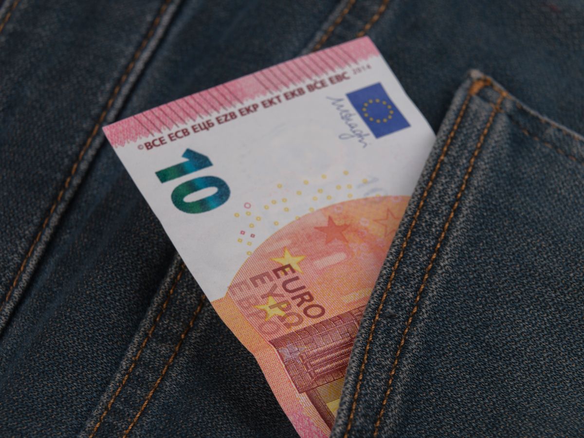 Banknot dziesięcioeurowy wystający z kieszeni spodni