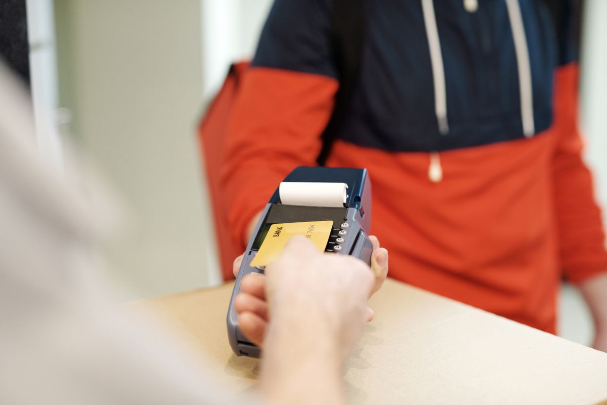 Klient płaci kartą zbliżeniowo na terminalu podanym przez sprzedawcę