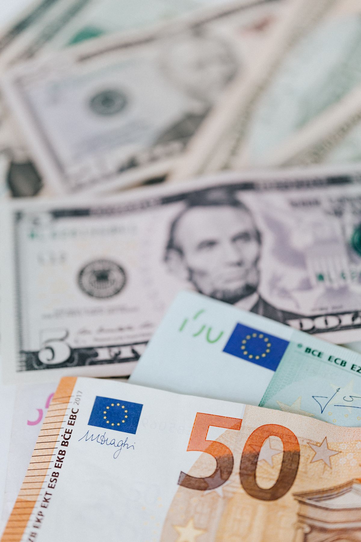 Banknoty euro i dolary amerykańskie ułożone jeden na drugim