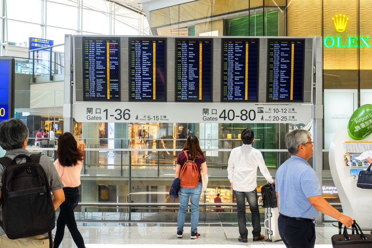 Pasażerowie sprawdzają tablicę odlotów na lotnisku