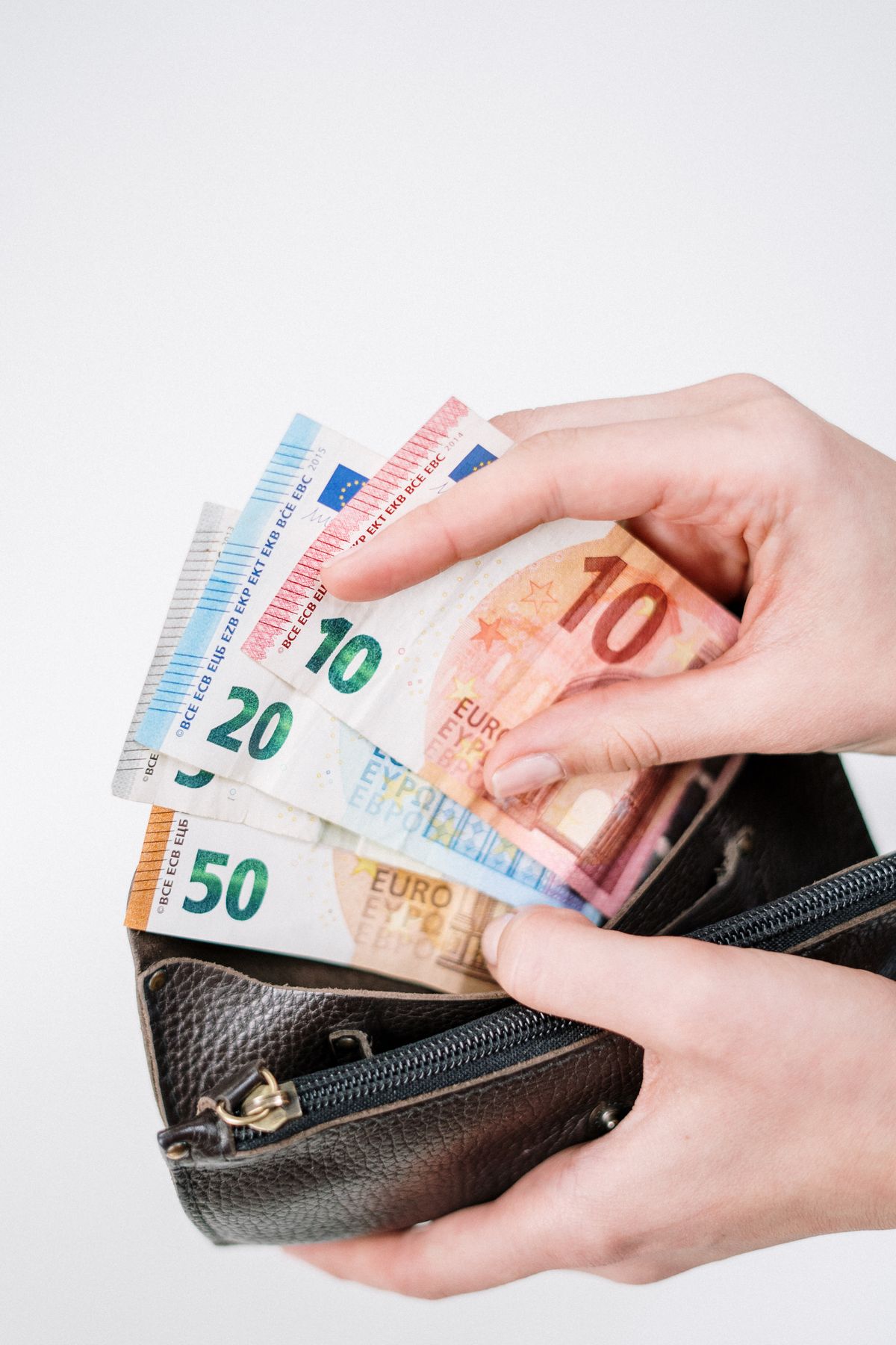 Dłoń wyjmująca banknoty euro z portfela