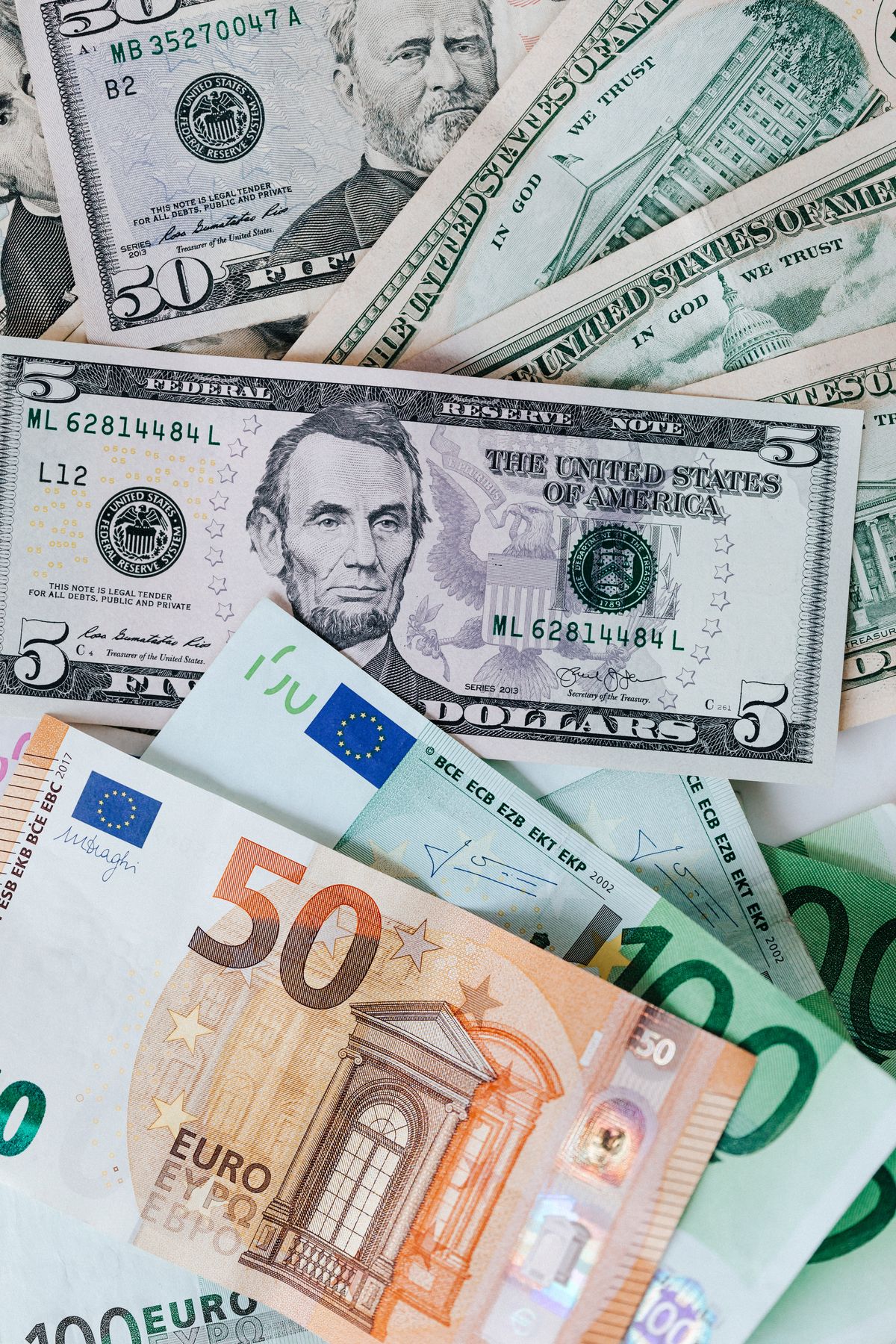 Zmięte banknoty dolarowe i euro rzucone na stos
